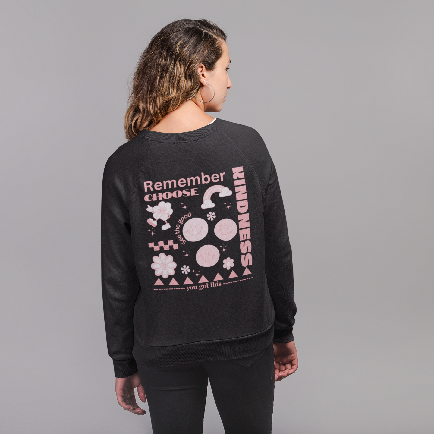 Black sweatshirt with pink retro graphic on the back featuring the words "Remember Choose Kindness," smiley faces, flowers, rainbows, and the phrases "see the good" and "you got this"
