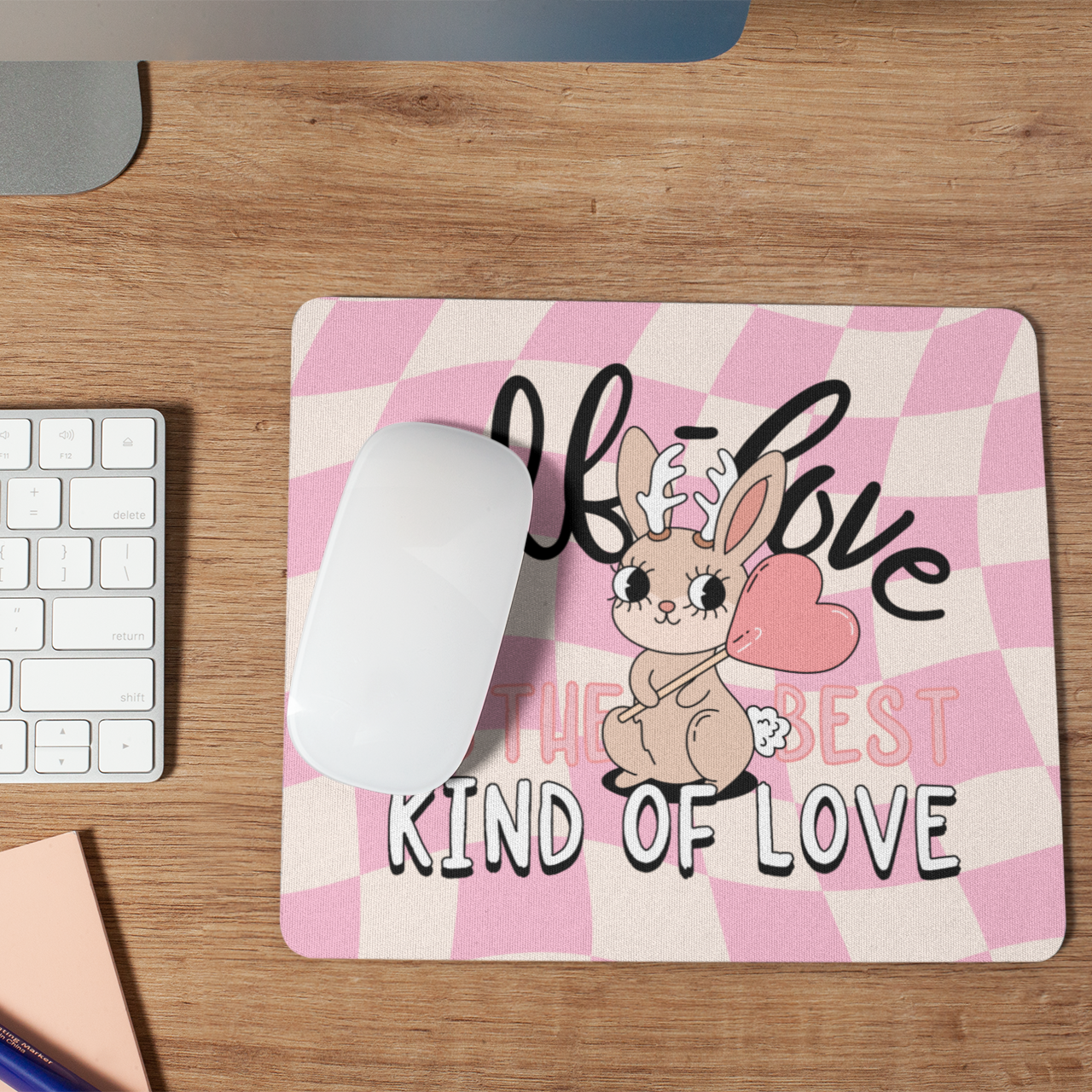 Mouse pad with a cartoon rabbit design on a desk with a keyboard and mouse.