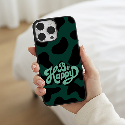 Phone case with 'Be Happy' text on a camouflage pattern held by a person.